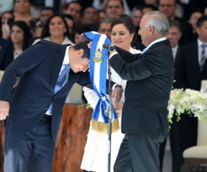 New Honduran President Juan Orlando Hernandez (L), accompanied by his wife Ana Garcia, receives the presidential sash from Congress prersident Mauricio Oliva, during his inauguration on January 27, 2014. (AFP/Orlando Sierra)