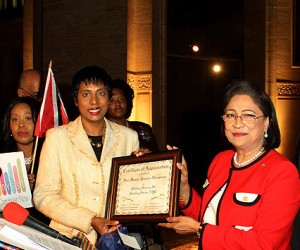 Invest Caribbean Now Founder/Chairman Felicia Persaud, l, presents a certificate of appreciation to Trinidad & Tobago Prime Minister Kamla Persad-Bissessar as ICN President Sheila Newton-Moses, far left, looks on. (Hayden Roger Celestin image)