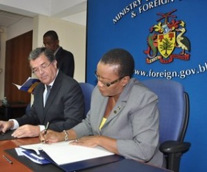 Minister of Foreign Affairs and Foreign Trade, Senator Maxine McClean signing the MOU while Canada's High Commissioner to Barbados, Richard Hanley, looks on. (A.Miller/BGIS)