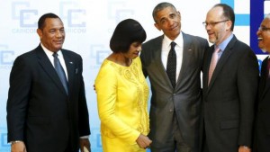 Obama reacts as Simpson Miller insists on standing next to him after moving aside Christie, as Obama joins a meeting of the leaders of CARICOM, the Caribbean Community nations, at the University of the West Indies in Kingston
