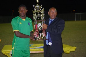 Dominica Football Association President Glen Etienne Presents The WIFA Men's Championship Trophy to St Vincent and the Grenadines Captain Dorren Hamlet (Anthony Debeauville)