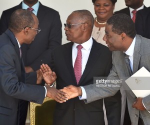 Former Prime Minister, Evans Paul (L) shakes hands with New Prime Minister of Haiti, Enex Jean-Charles(R)as Haitian President, Jocelerme Privert stands by during the installation ceremony of the new Prime Minister and installation of the new government, in the National Palace of Haiti, in Port-au-Prince, on March 28, 2016. (AFP / HECTOR RETAMAL)