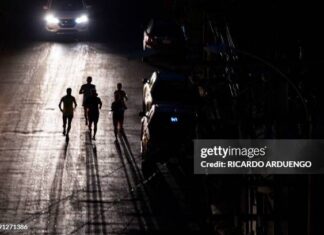 Joggers exercise on a dark street in San Juan, Puerto Rico after a major power outage hit the island on December 31, 2024.