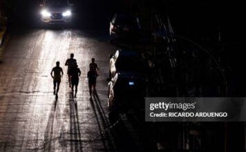 Joggers exercise on a dark street in San Juan, Puerto Rico after a major power outage hit the island on December 31, 2024.